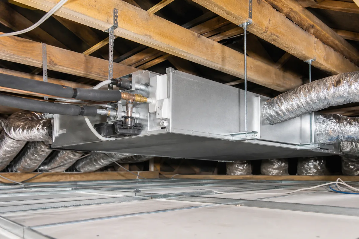 Concealed ducted air conditioning unit being installed in a ceiling void with flexible ducts