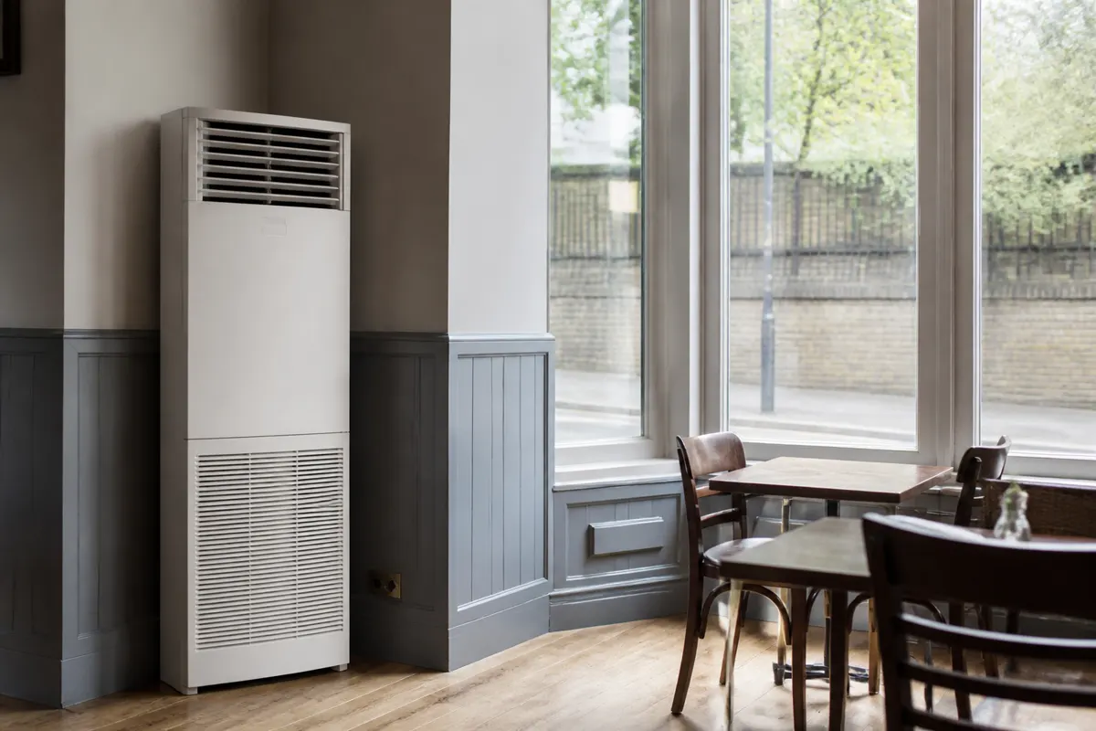 Tall floor-standing indoor air conditioner in the corner of a UK cafe